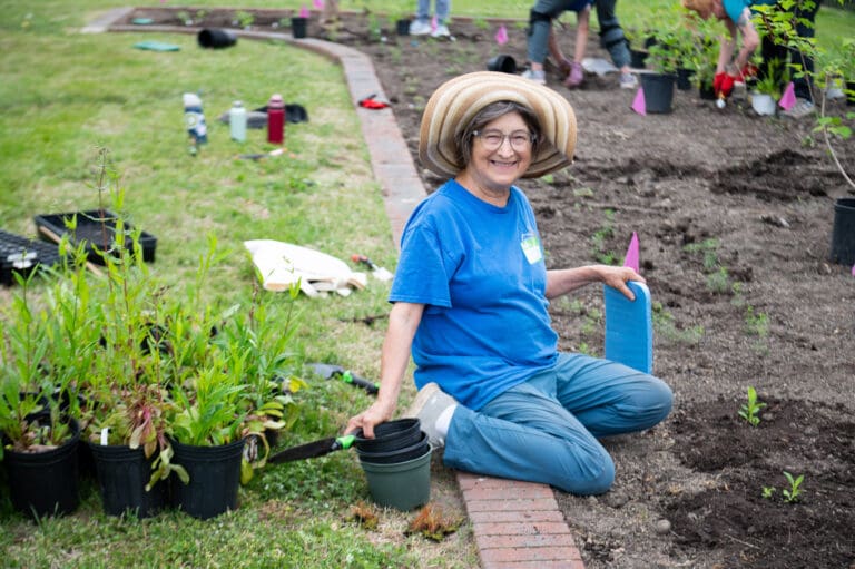 Volunteer smiles while helping plant at Huntington Botanical Gardens.