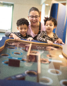 A mom and her two kids play a game in the exhibit Oceanbound at the Virginia Living Museum