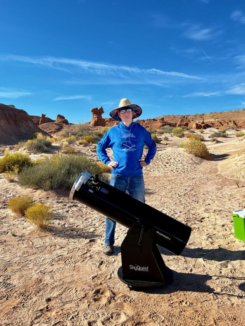 Dr. Rutkowski stands behind a telescope to observe his first annular ("Ring of Fire") eclipse.