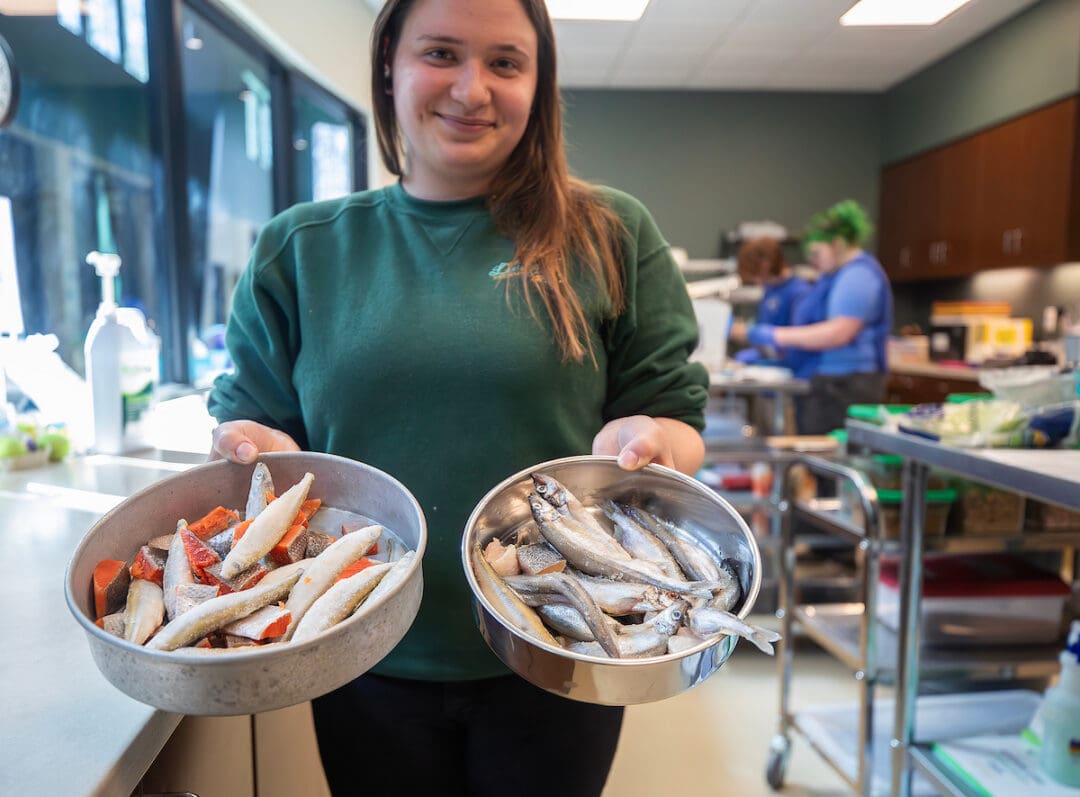 Virginia Living Staff member holding bowls of fish.